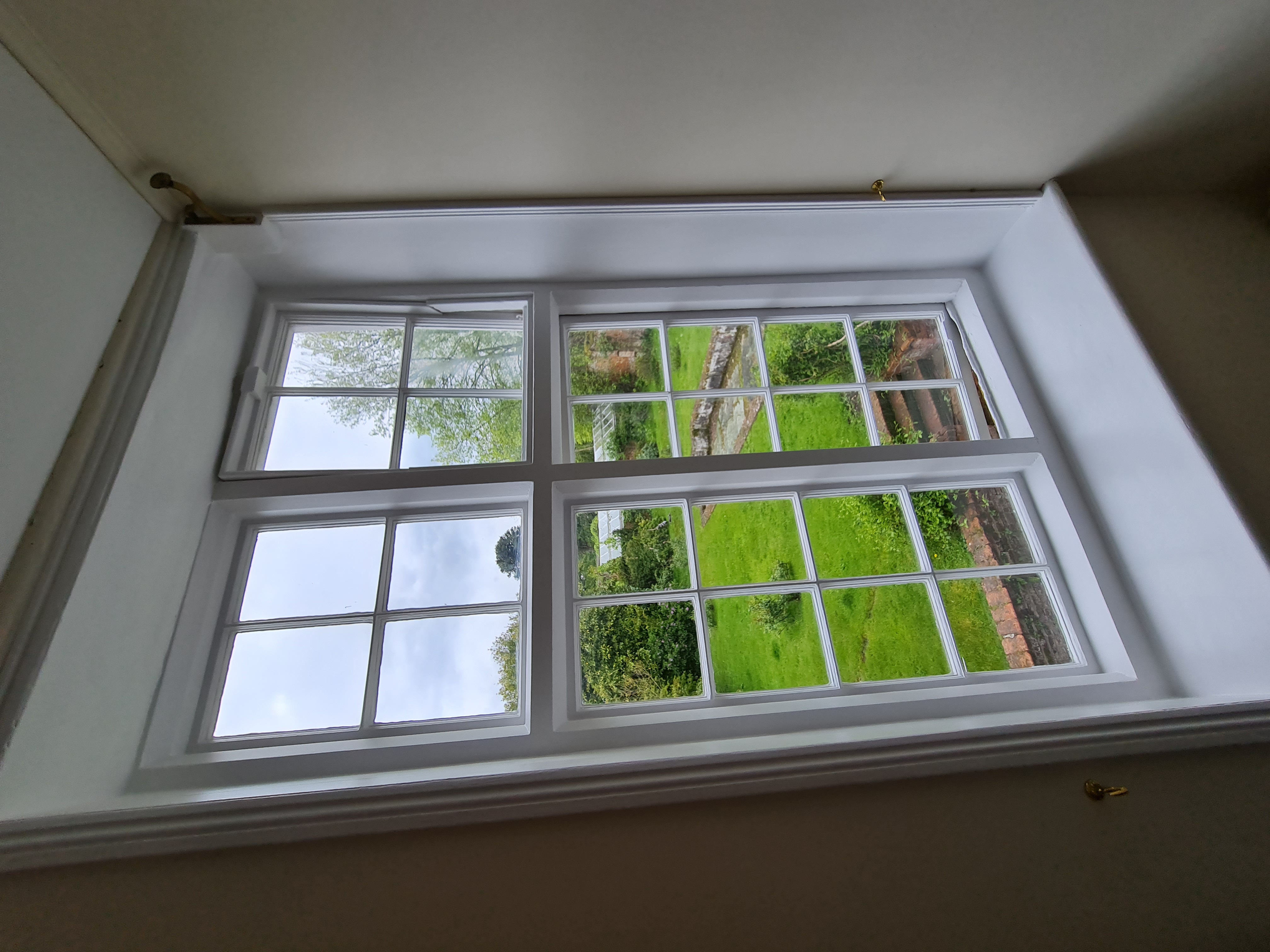 Freshly painted sash window with countryside garden view